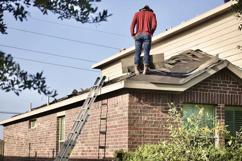 Professional roofer working on a residential roof in Lee Manor